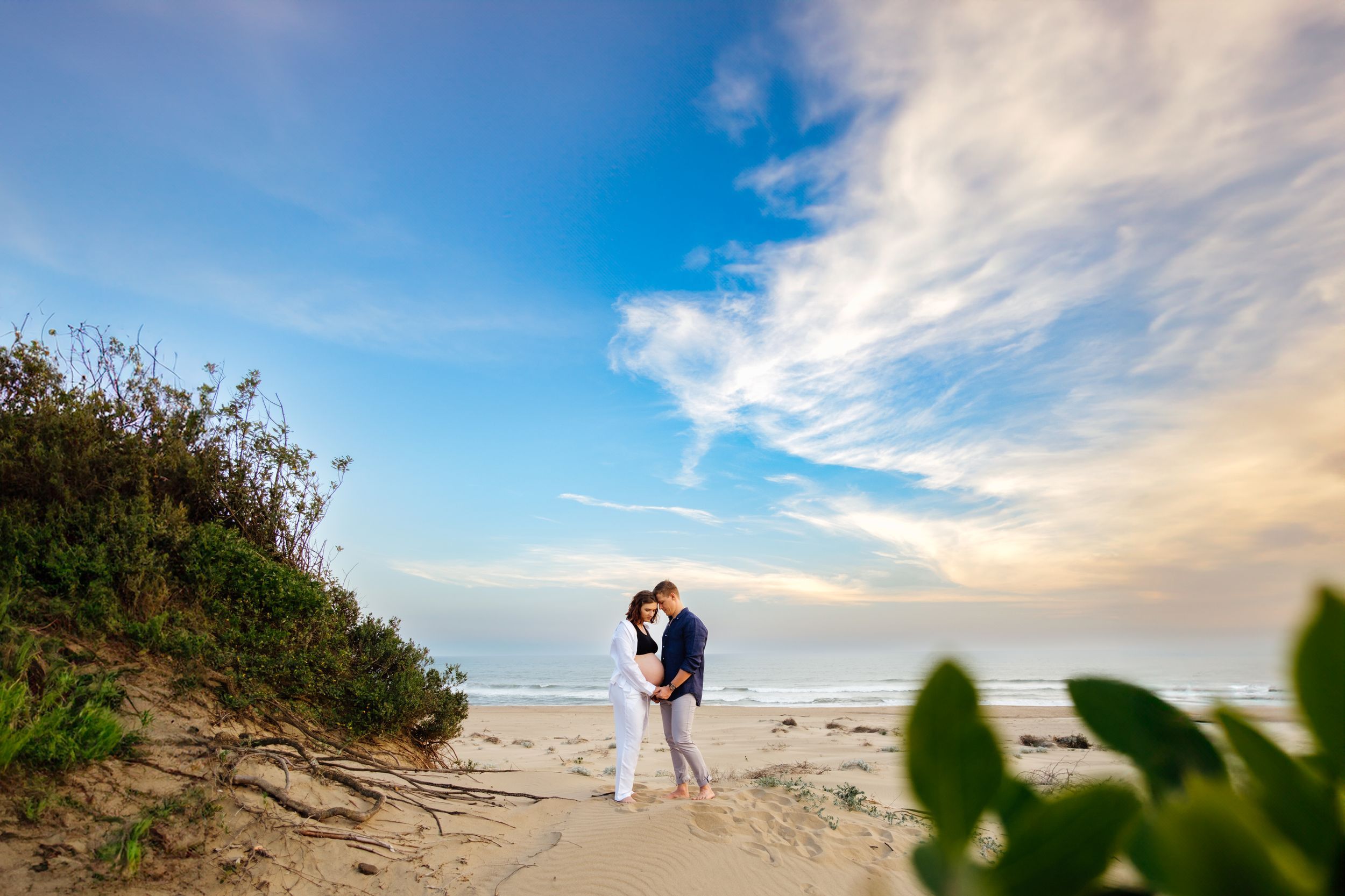 Maternity couple on the beach in Mtunzini with dramatic sky and ocean backdrop