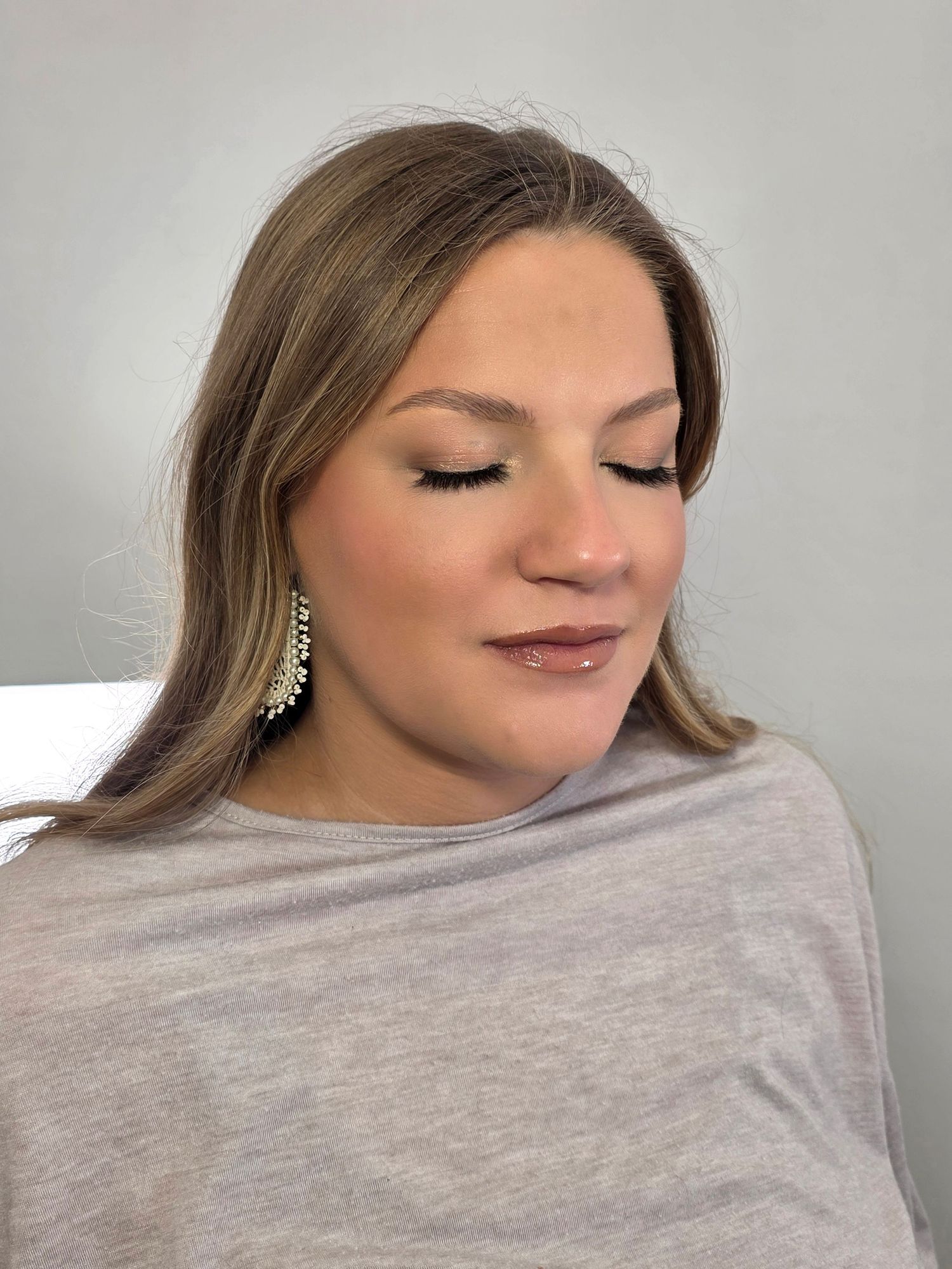 Professional makeup application shots showing neutral tones and navy blue attire.