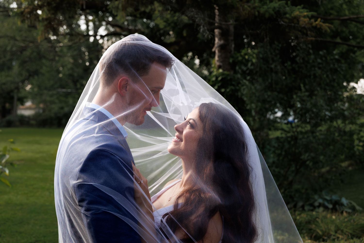 Artsy elopement photography of a couple sharing a quiet moment beneath a wedding veil