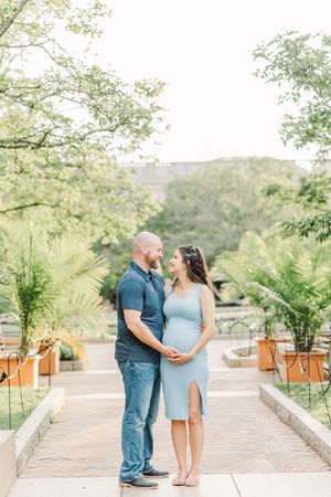 Couple in blue and mint dress sharing intimate moment during maternity photoshoot.