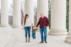 Family members walking and interacting between classical white columns.