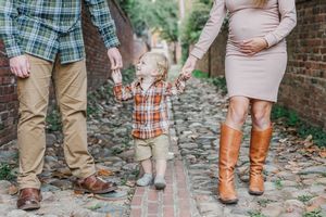 Casual family footwear photo showing boots and shoes on cobblestone path.