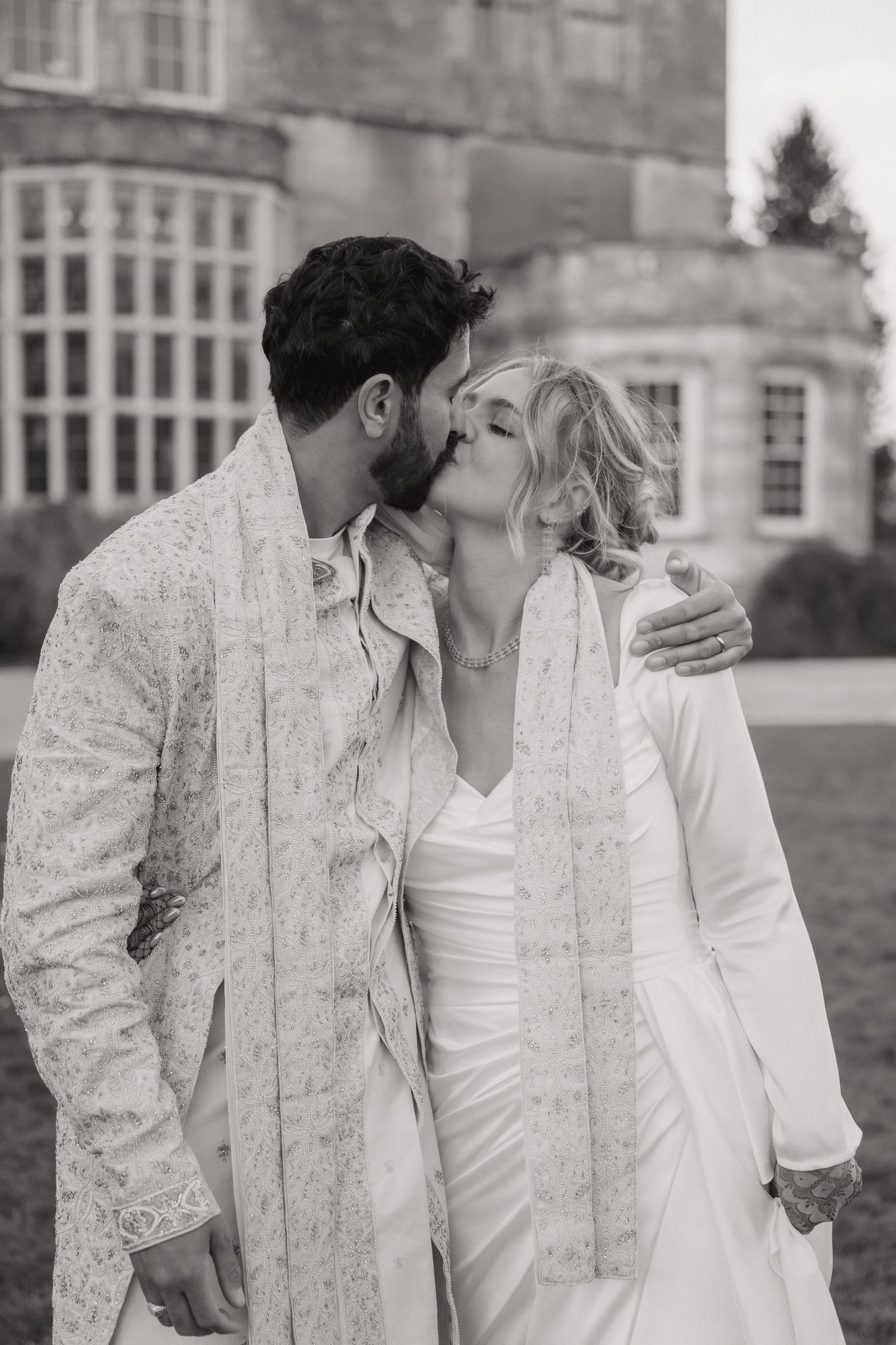 A romantic black and white photo sequence showing a couple sharing tender moments in front of a stately building.