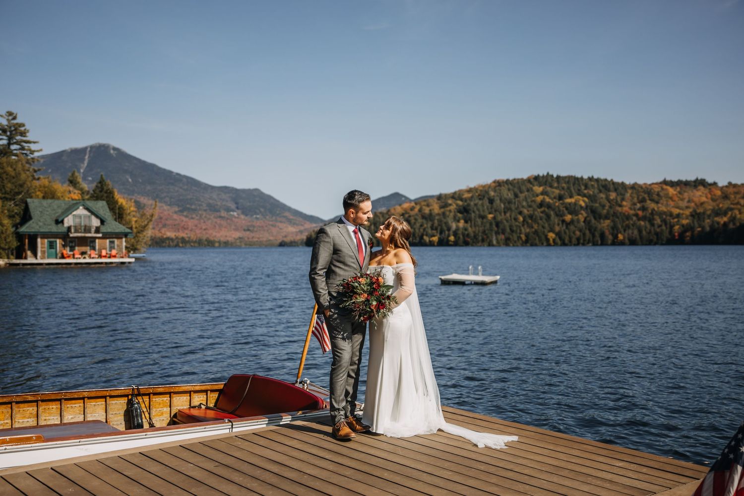 couple eloping on a dock in the fall on Lake Placid with the views of whiteface mountain in the adirondacks