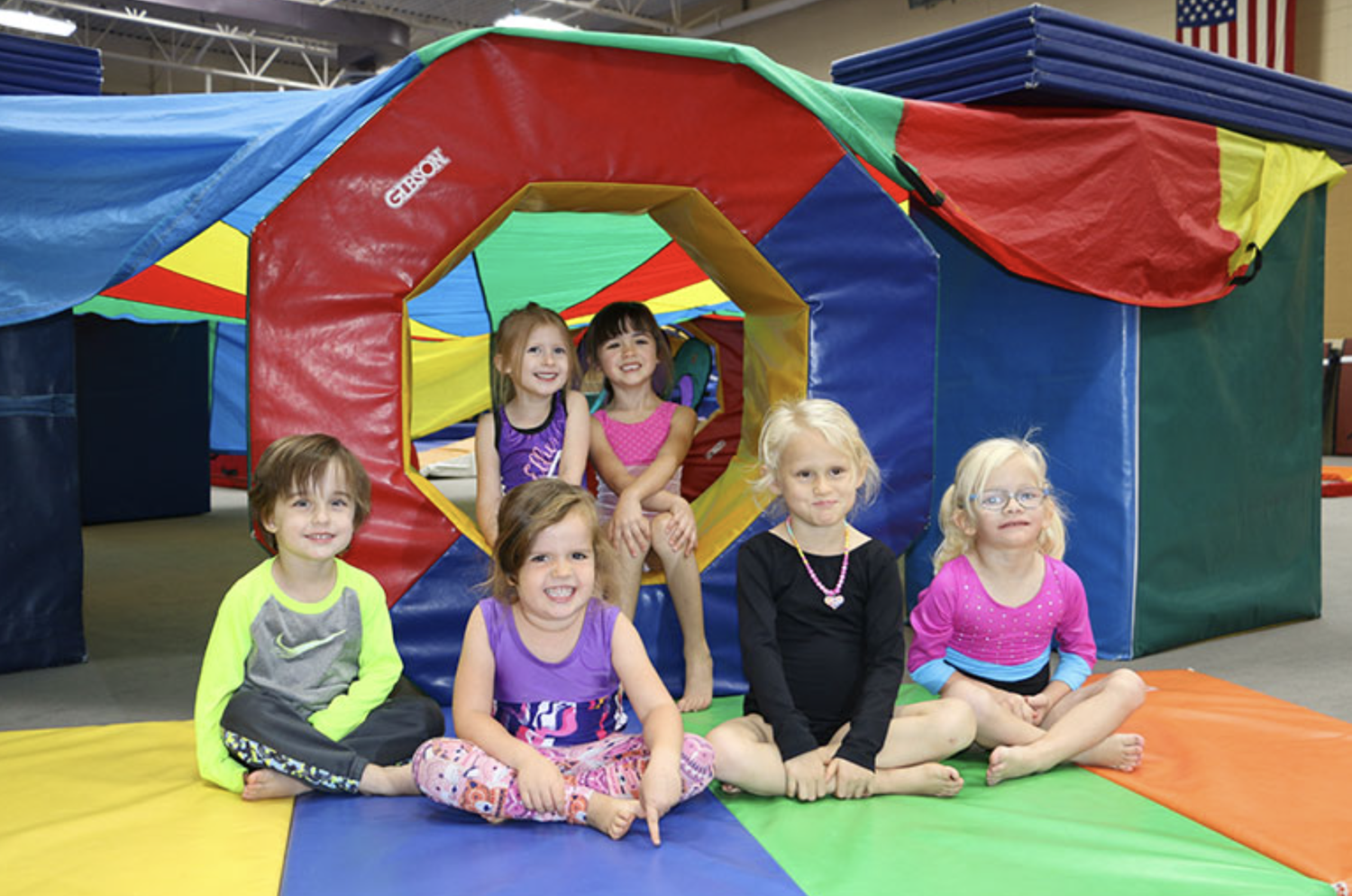 Little girls posed in front of gymnastics equipment in a Littleton, CO rec center