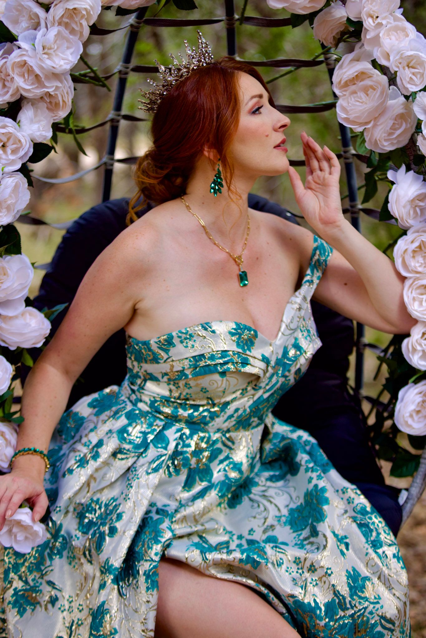 Elegant turquoise and white gown with floral details photographed against a backdrop of pink roses.