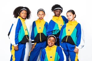 A group wearing matching blue, yellow and white athletic tracksuits poses together against a white background.