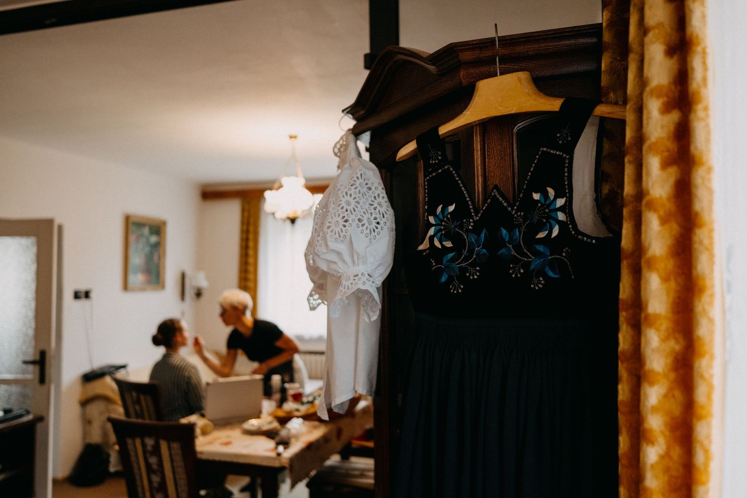 Dark silhouette of wedding preparations against window light in a traditional room.