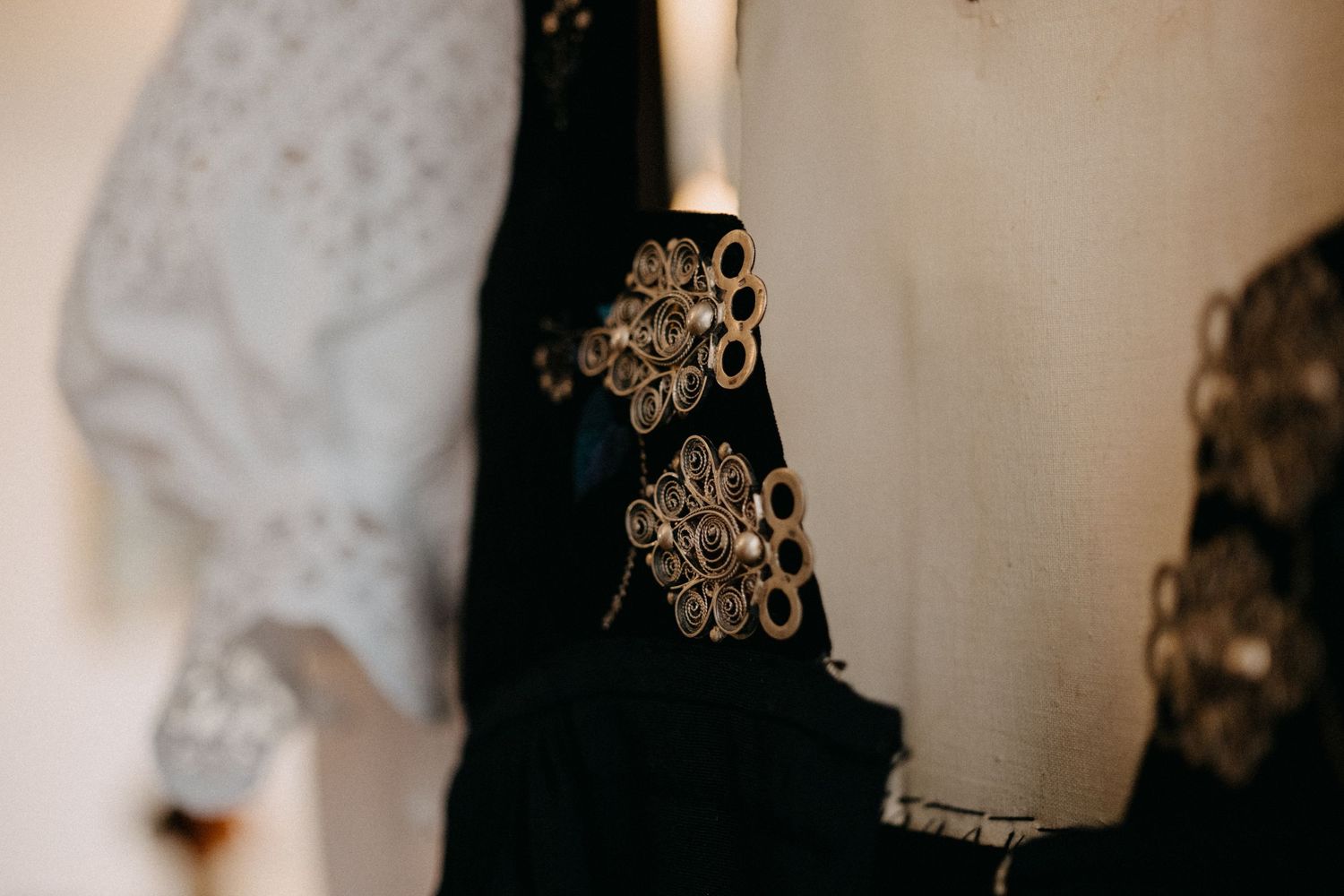 Close-up detail of delicate white lace fabric with intricate floral patterns and embroidery.