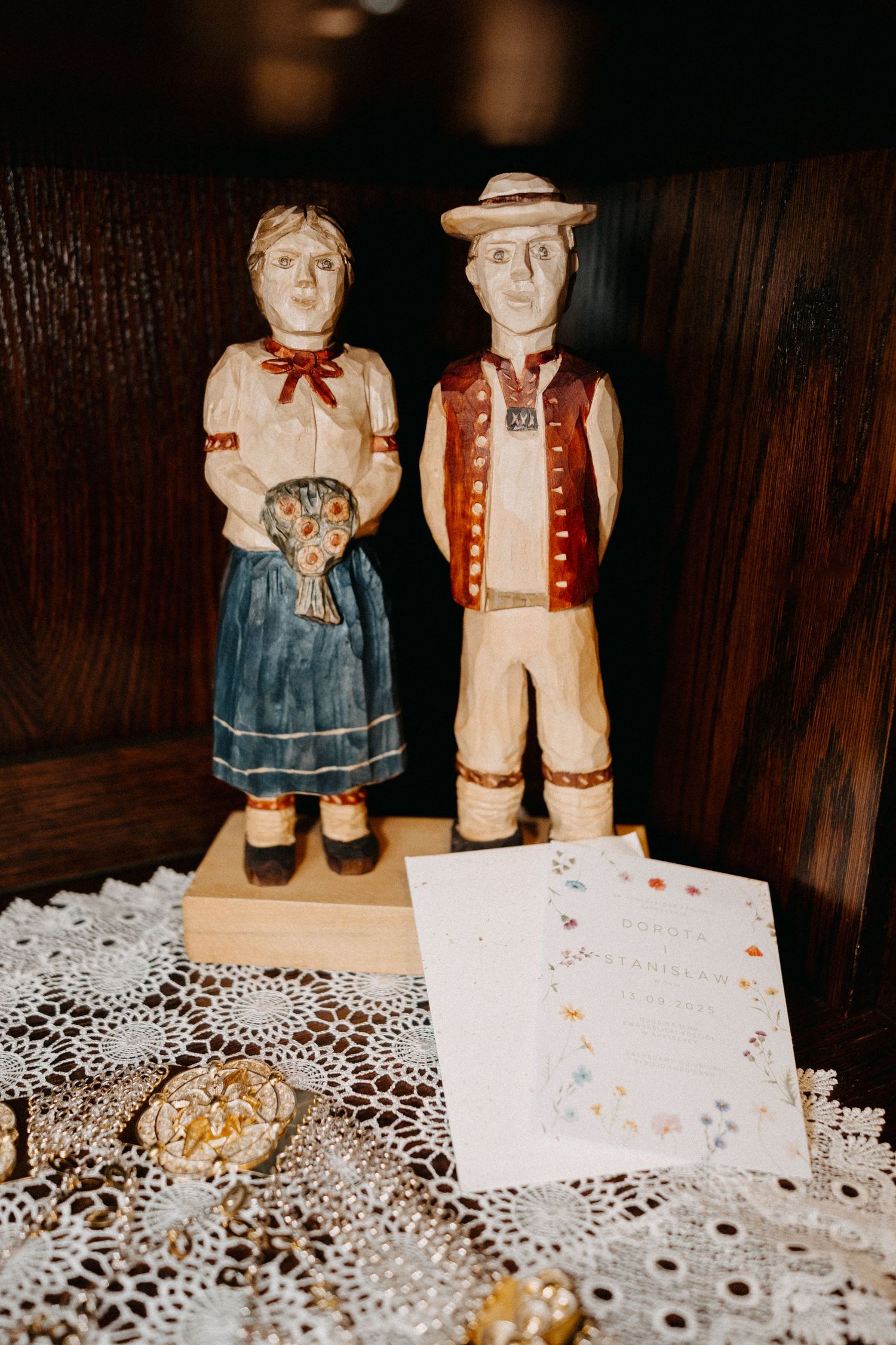 Decorative ceramic folk art figurines displayed on white lace doily.