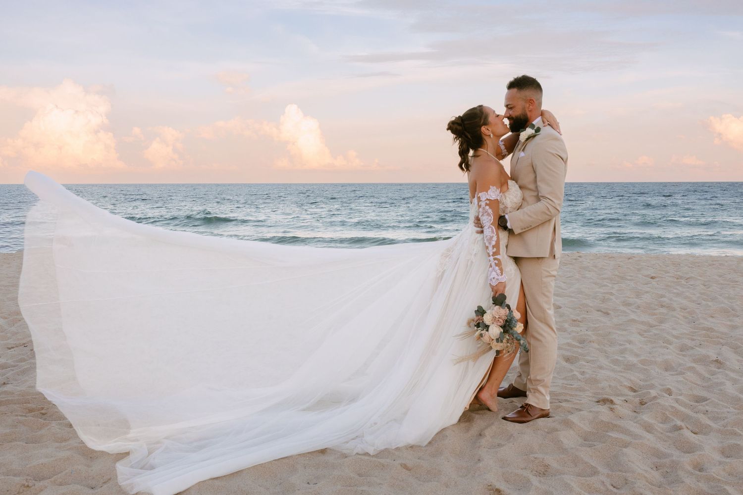 Bride and groom embracing on the beach in Fort Lauderdale in front of the Beach House Hilton
