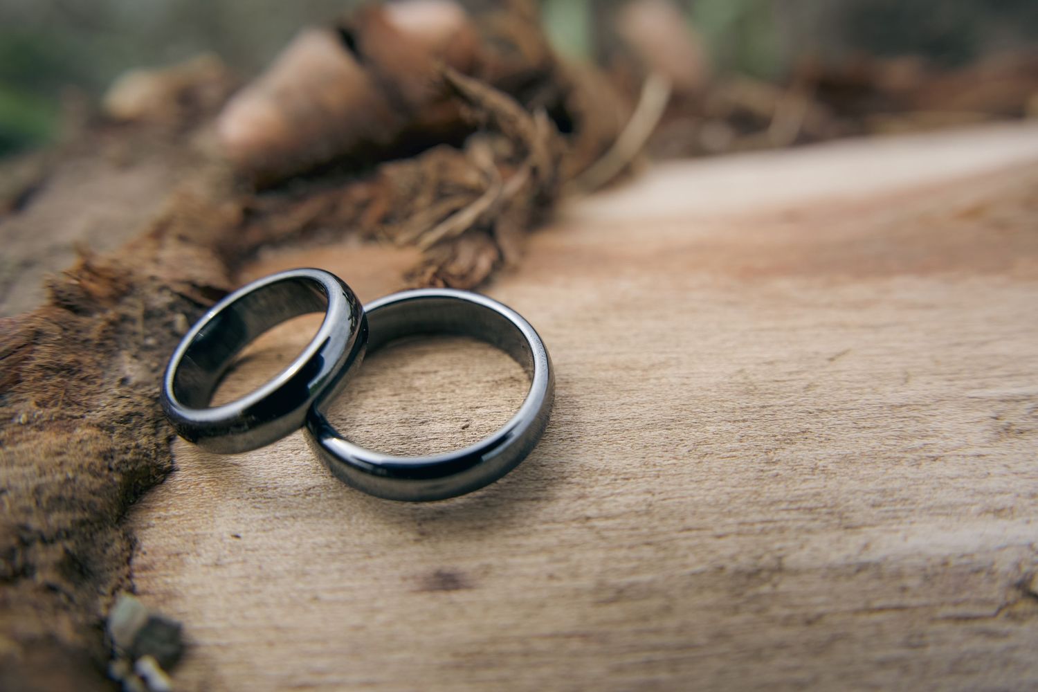 Seven close-up photos of silver wedding rings arranged on a rustic wooden surface in different angles and compositions.
