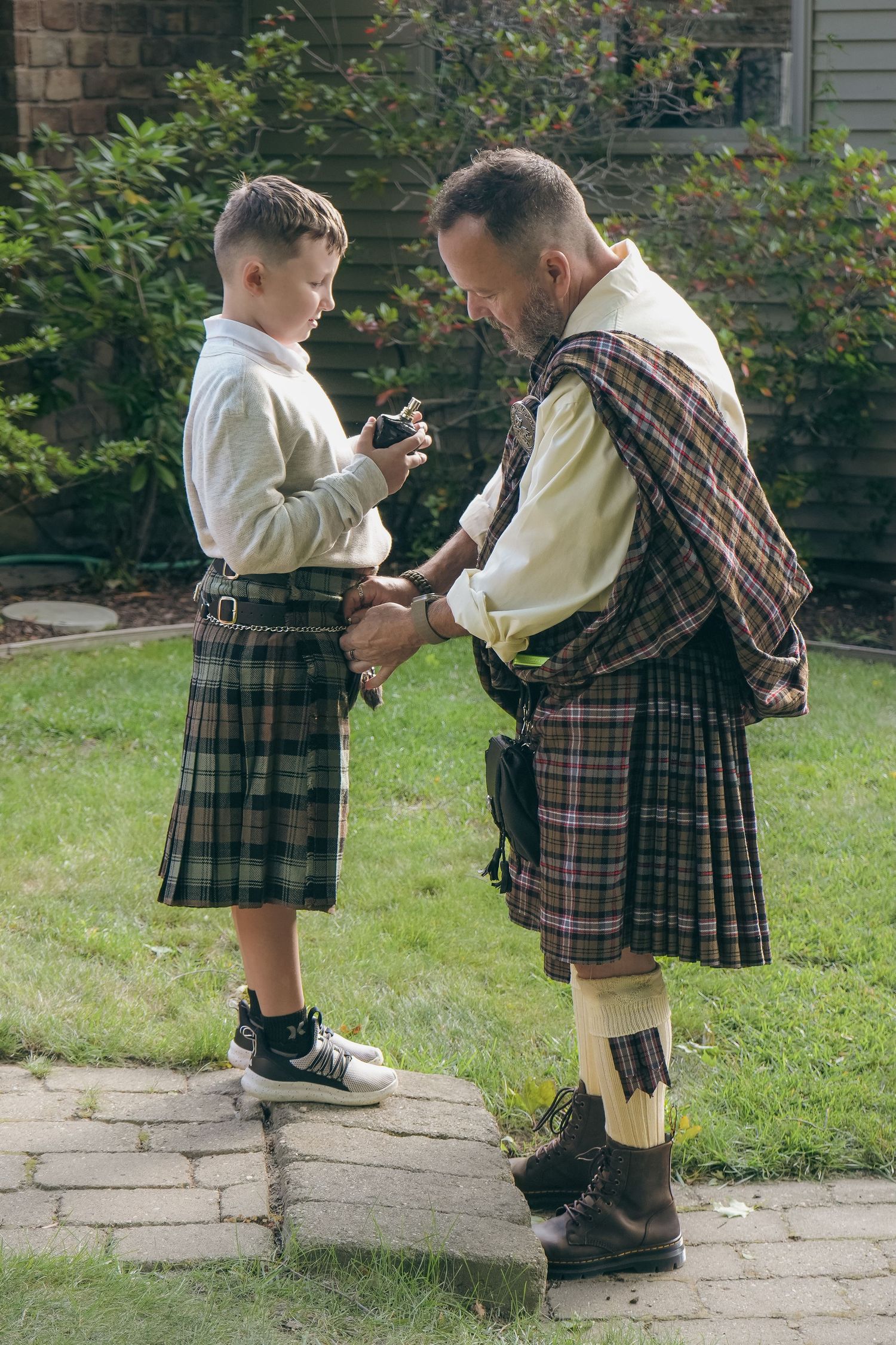 A series of photos showing a heartwarming moment between two people in traditional Scottish kilts and attire outdoors.