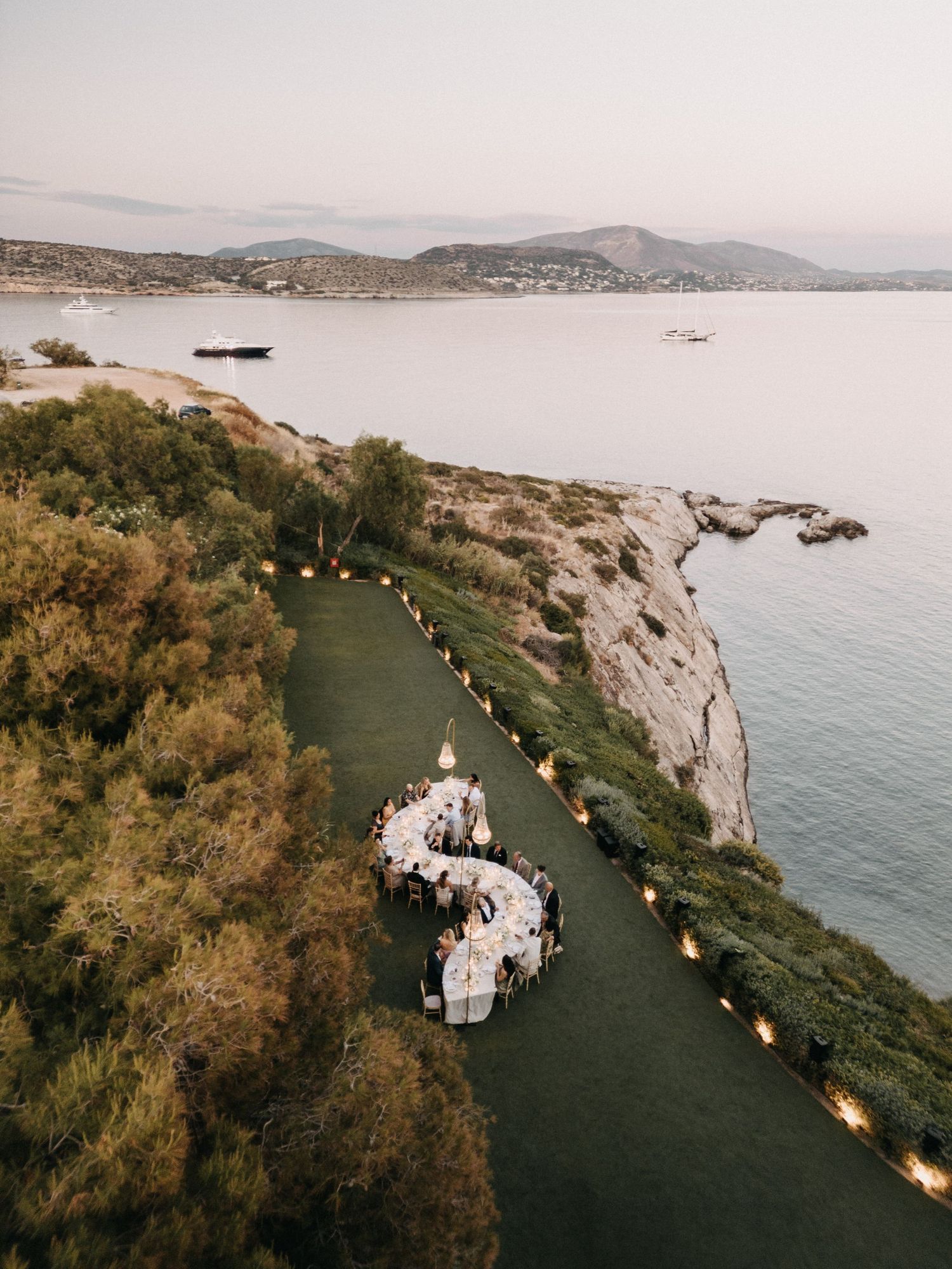 Aerial view of an outdoor wedding ceremony with guests seated in a unique arrow formation.