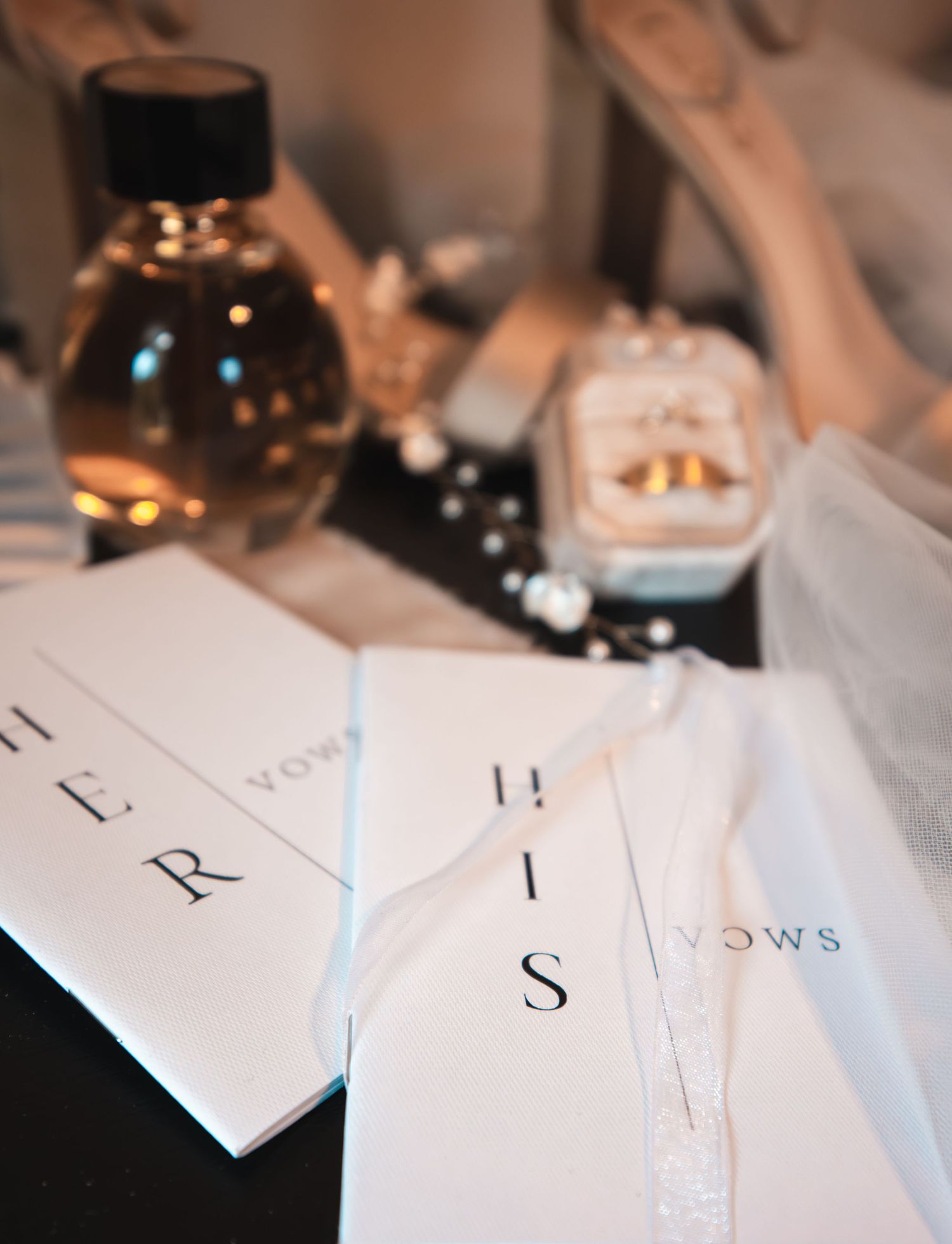 Wedding vows and rings arranged with perfume bottle in elegant flat lay composition.