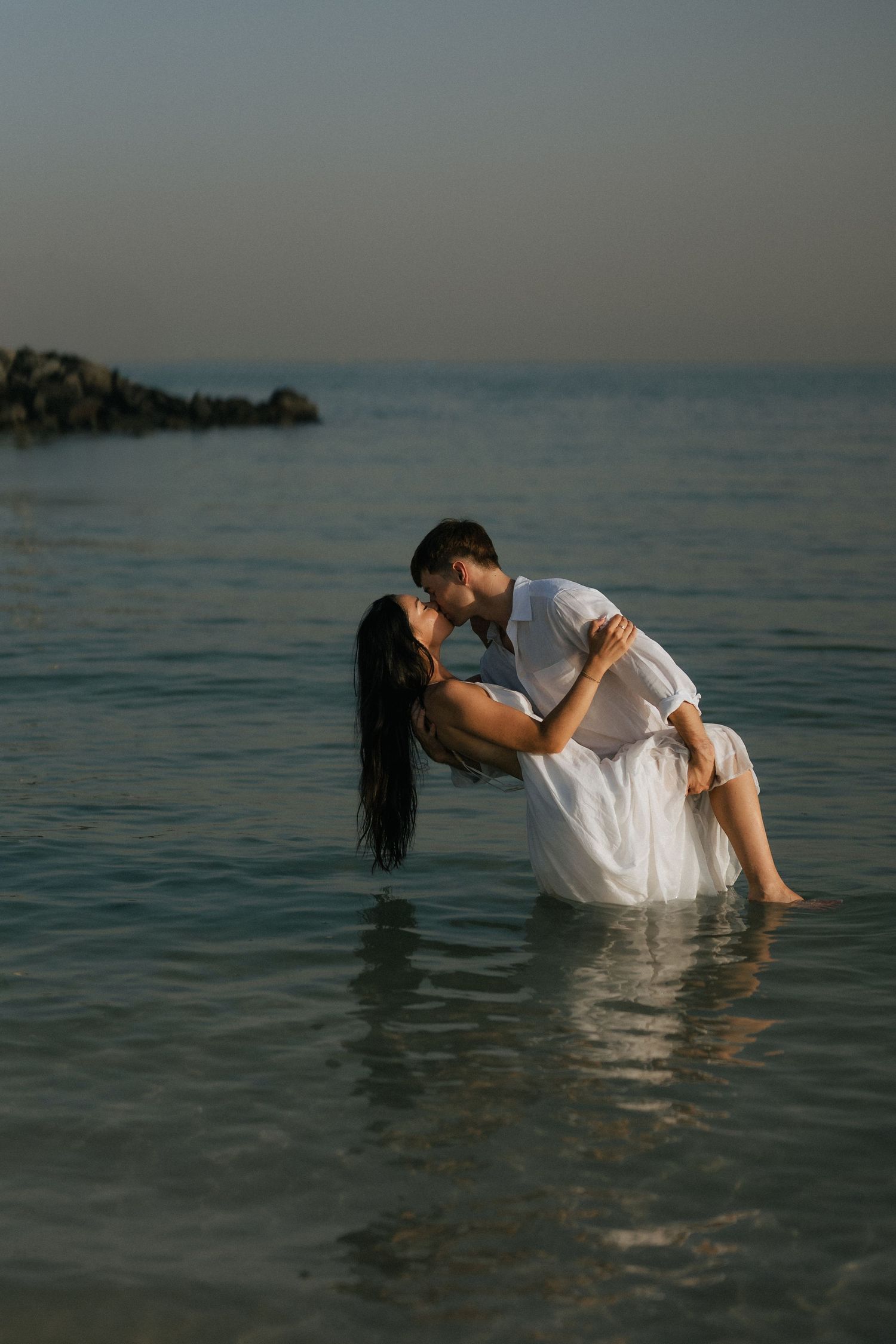 Romantic beach couple photoshoot in Dubai with couple standing in the sea