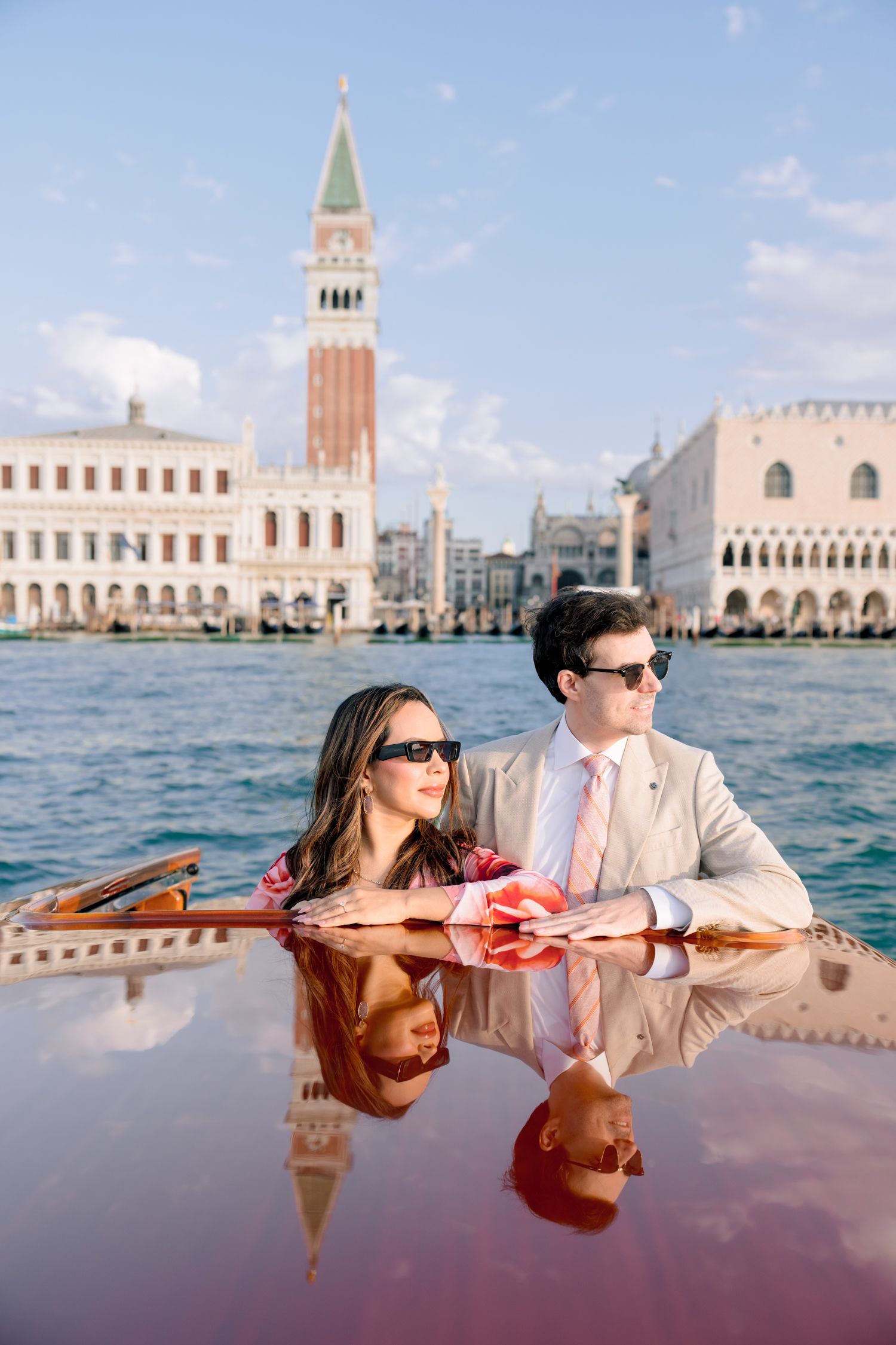 Couple enjoying a romantic boat ride in Venice with St Mark's Campanile and Doge's Palace in the background.