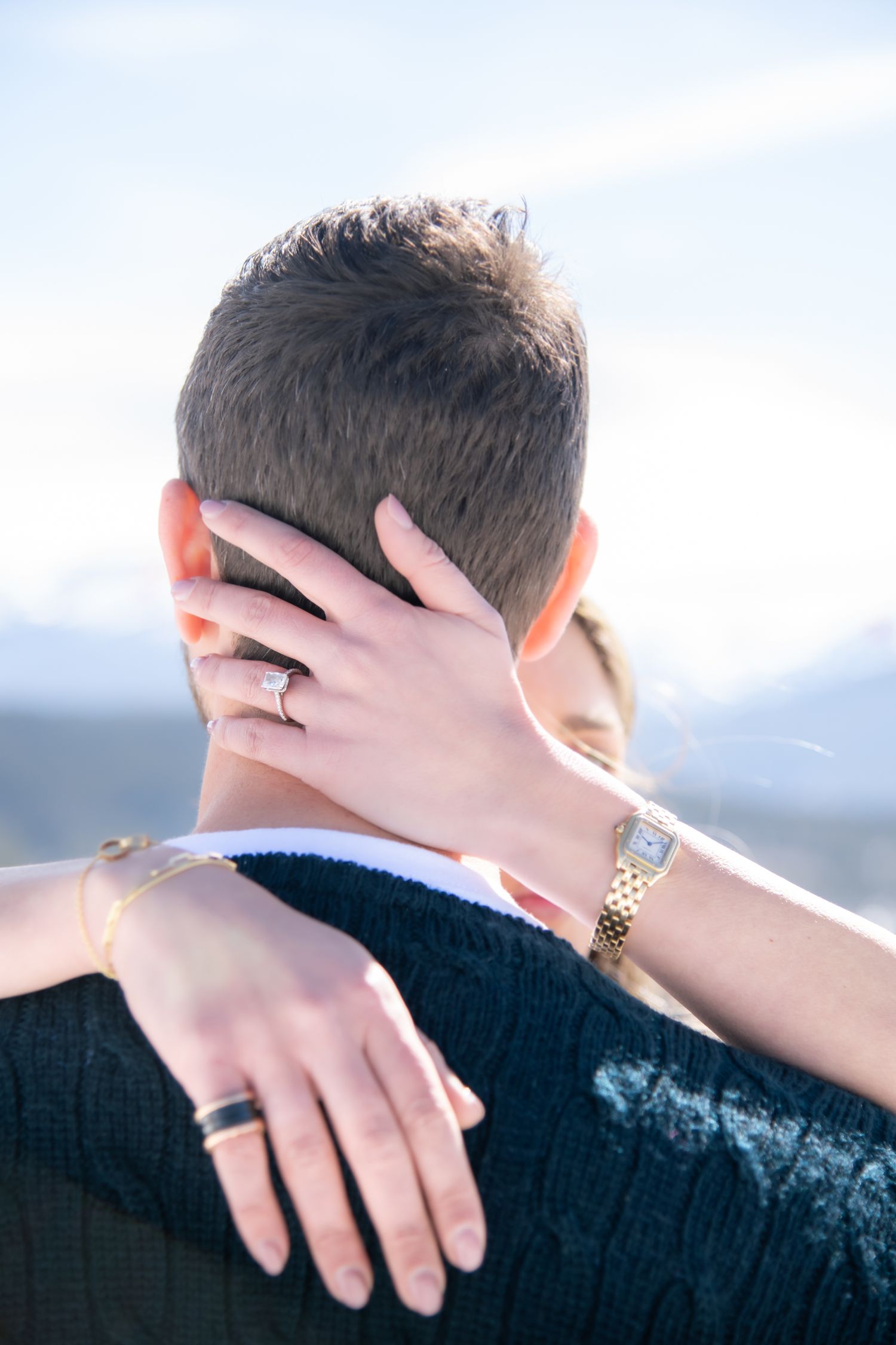 Artistic close up image of engagement ring and an embrace during Vail Colorado engagement photo session.