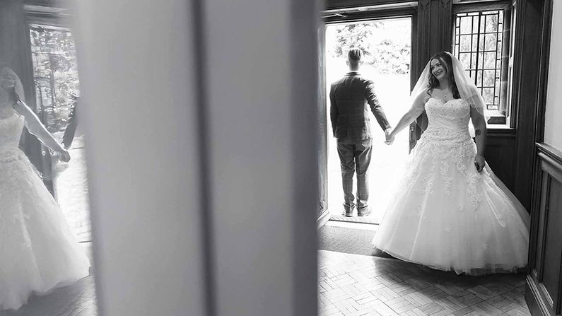 bride and groom share a first touch before getting married at Dalston hall wedding venue