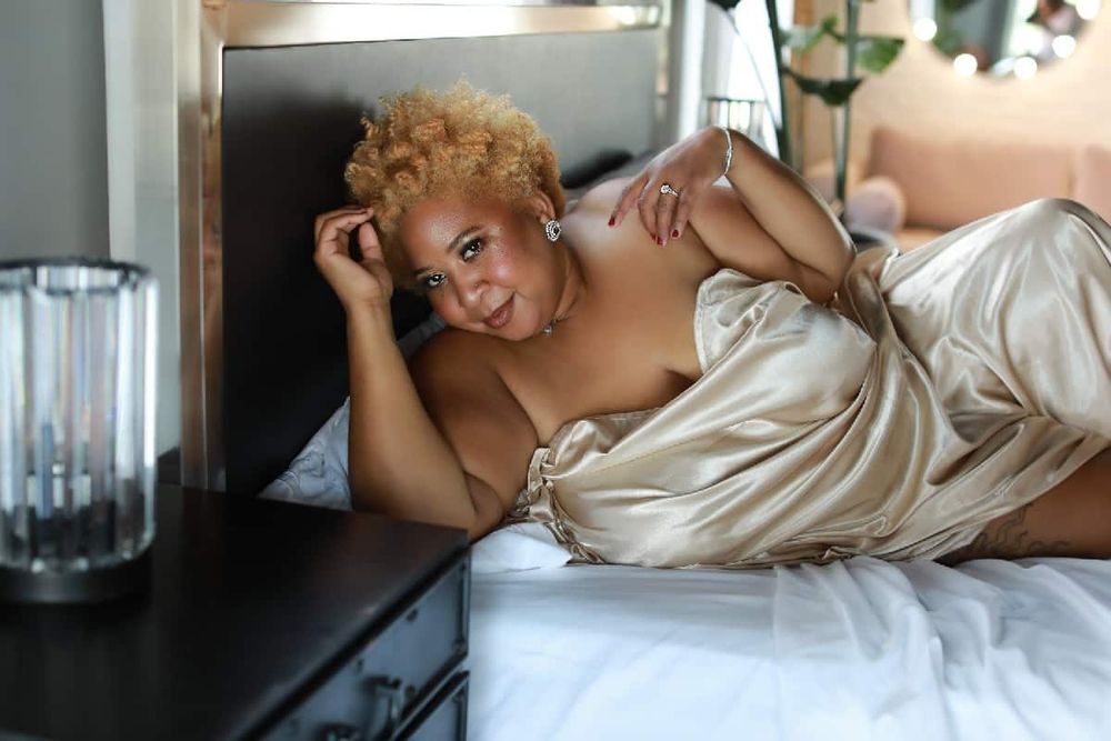 Relaxed portrait on couch in silk robe with modern decor.