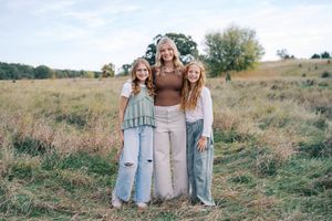 Family group photo session in a rustic outdoor field setting.