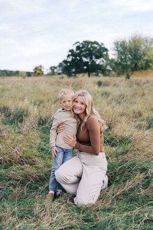A joyful outdoor photoshoot in a grassy field on a sunny day.