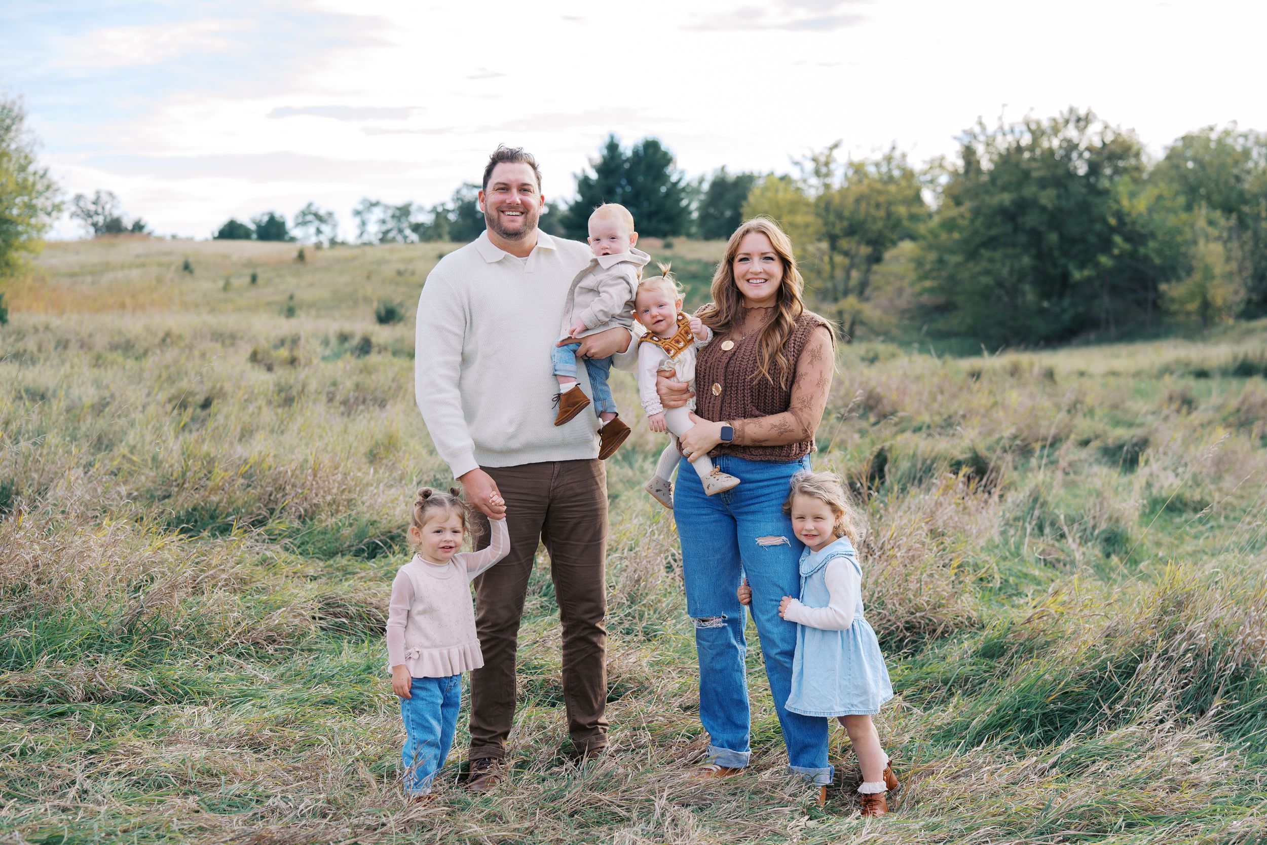 A series of candid outdoor family portraits taken in a rustic field setting during golden hour.