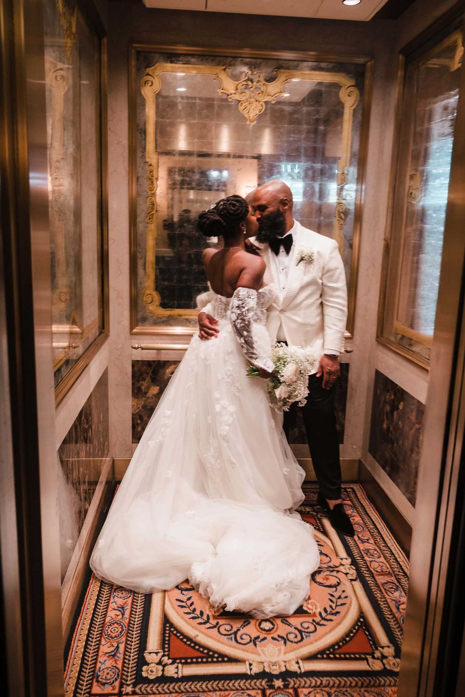 Bride and groom sharing a kiss inside historic elevator at Lenox Hotel Boston with vintage interior details