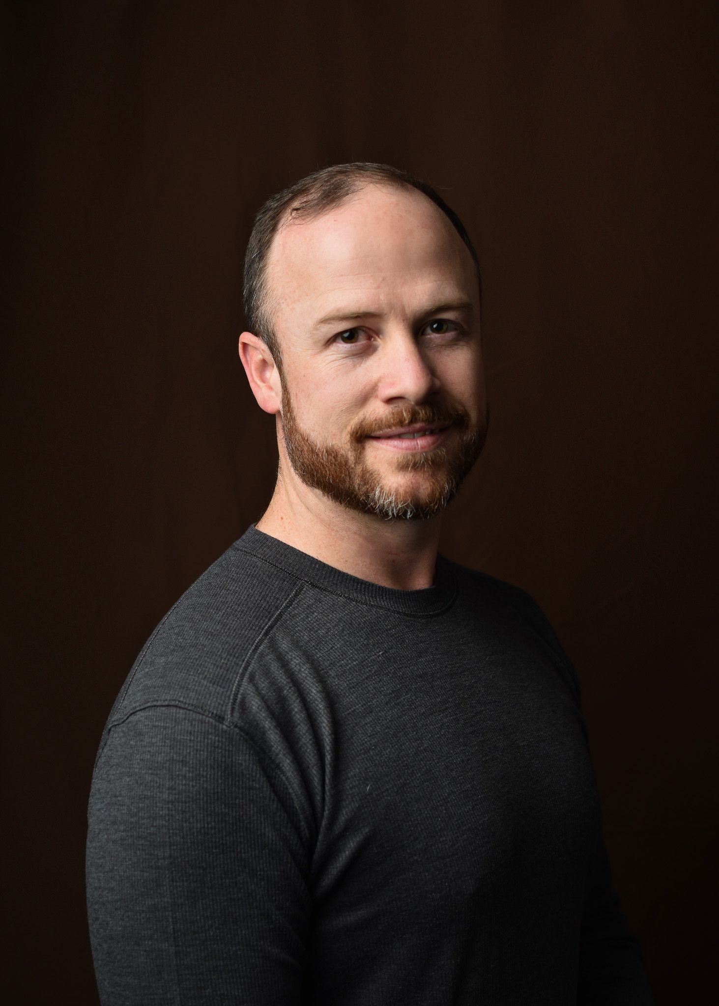 studio portrait, male, brown backdrop, gray sweater, beard, photography, single light