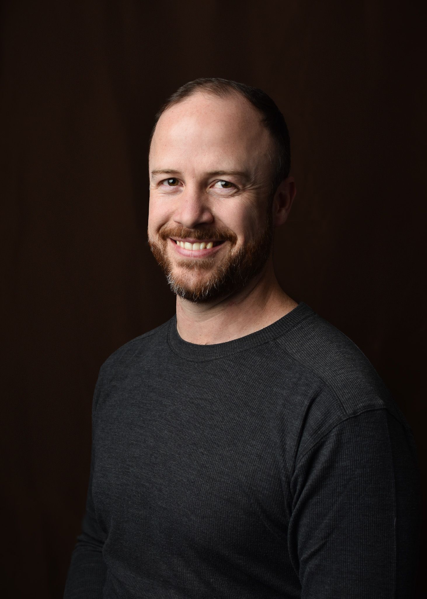 studio portrait, male, brown backdrop, gray sweater, beard, photography, single light