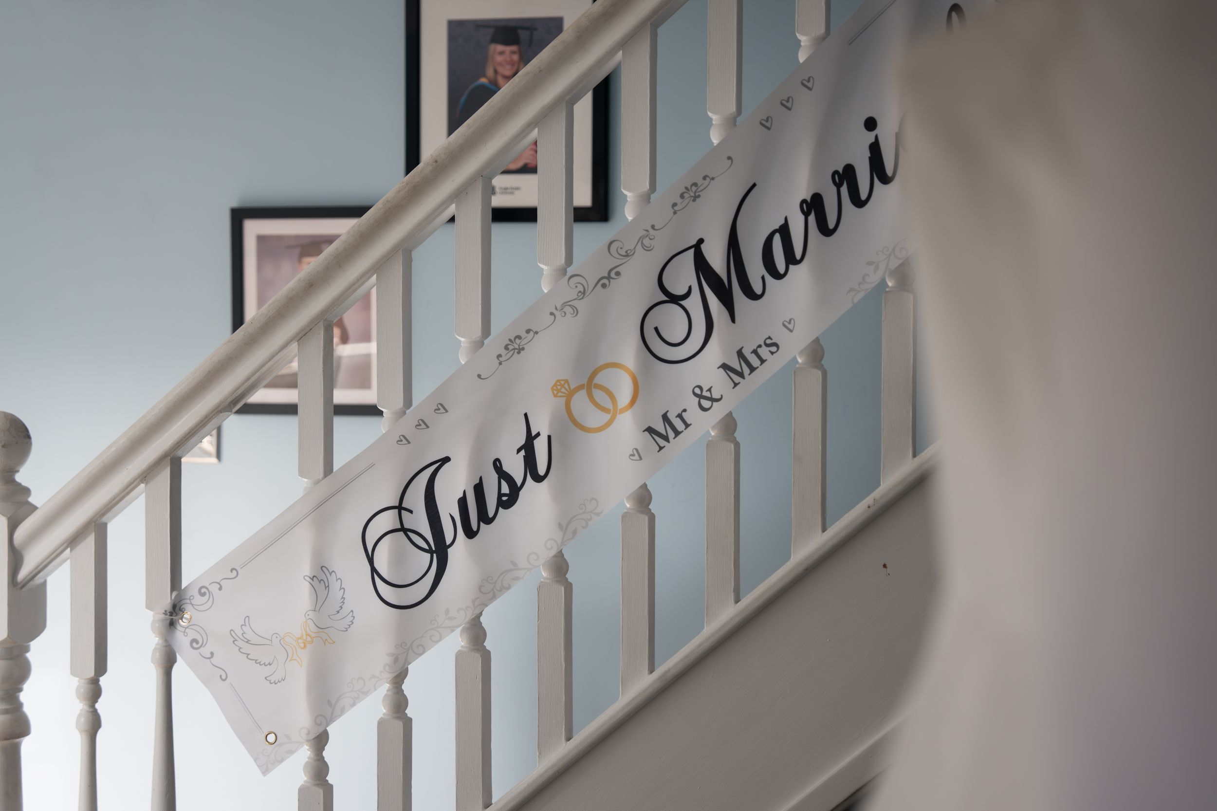 Elegant white stair railing detail with decorative molding against a light-colored wall in a classic interior setting.