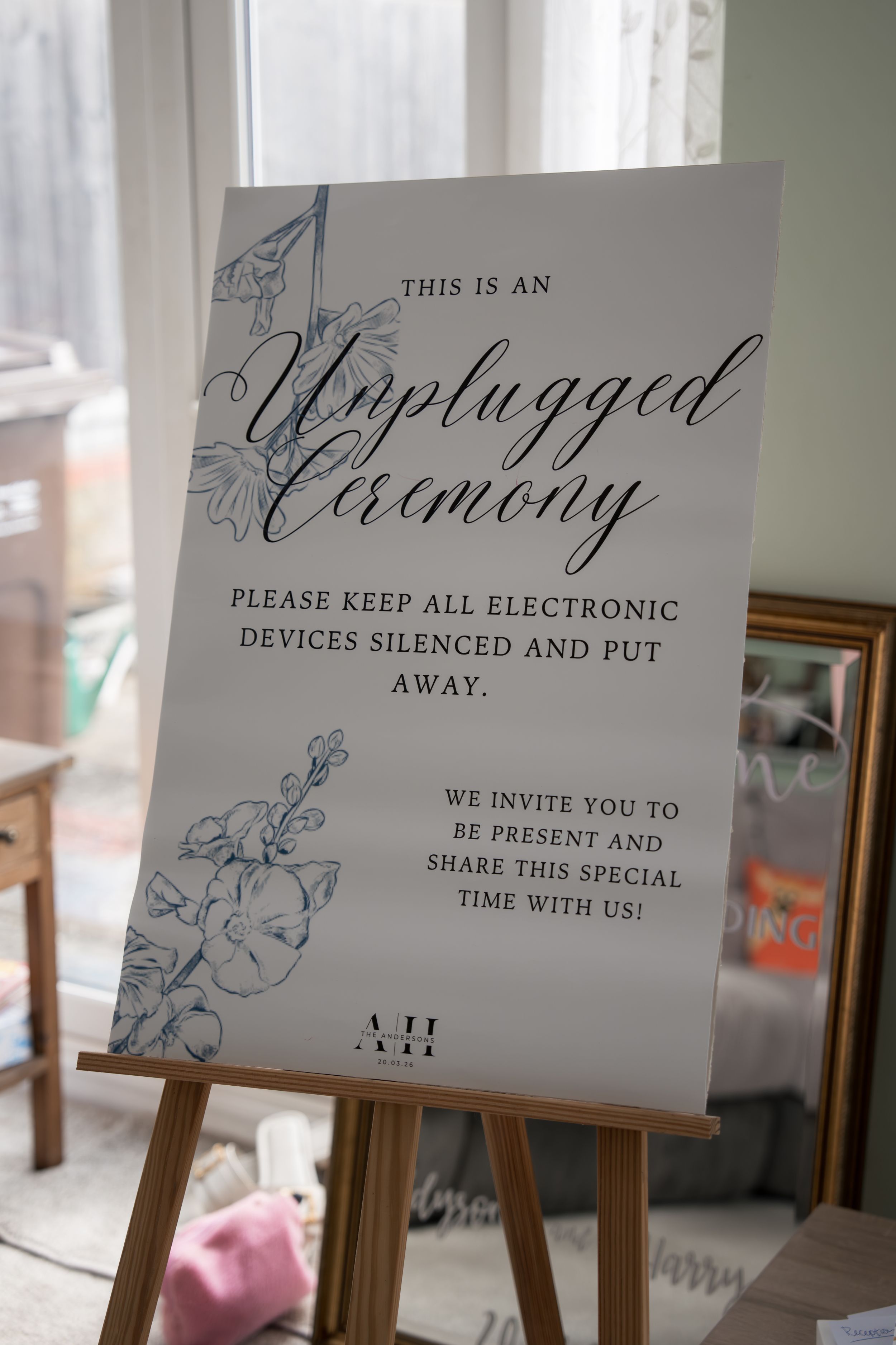 Three elegant wedding signs on wooden easels displaying 'Unplugged' and ceremony instructions with decorative floral designs.