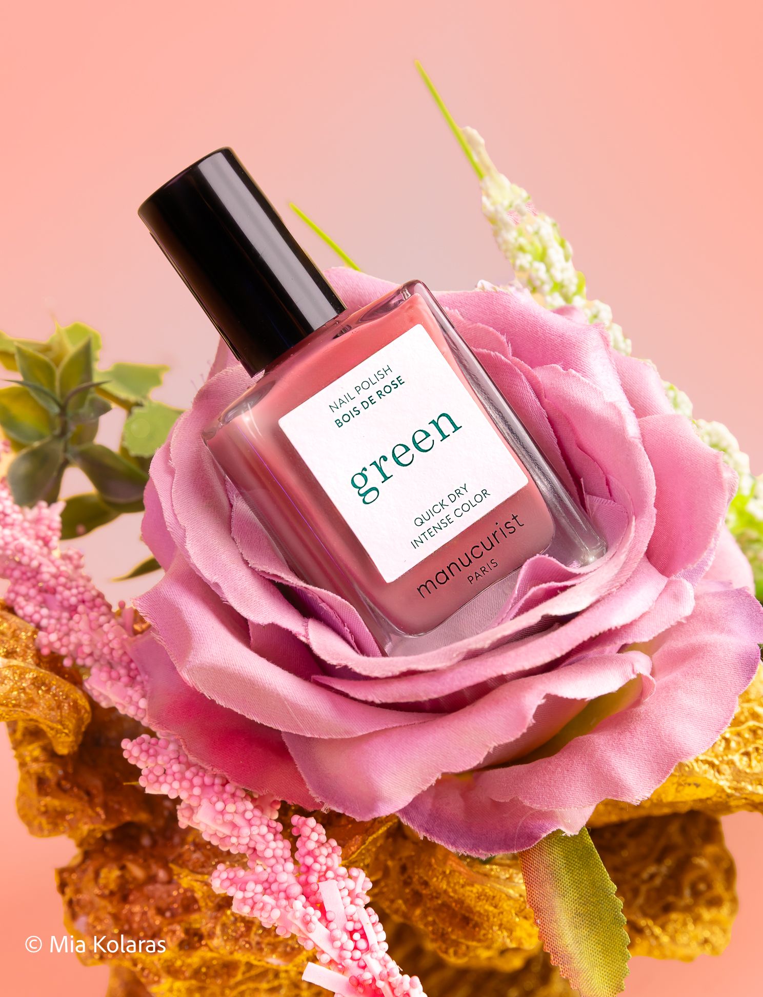 Manucurist brand, Pink nail polish in a rose with other plant-like objects, against a pink backdrop