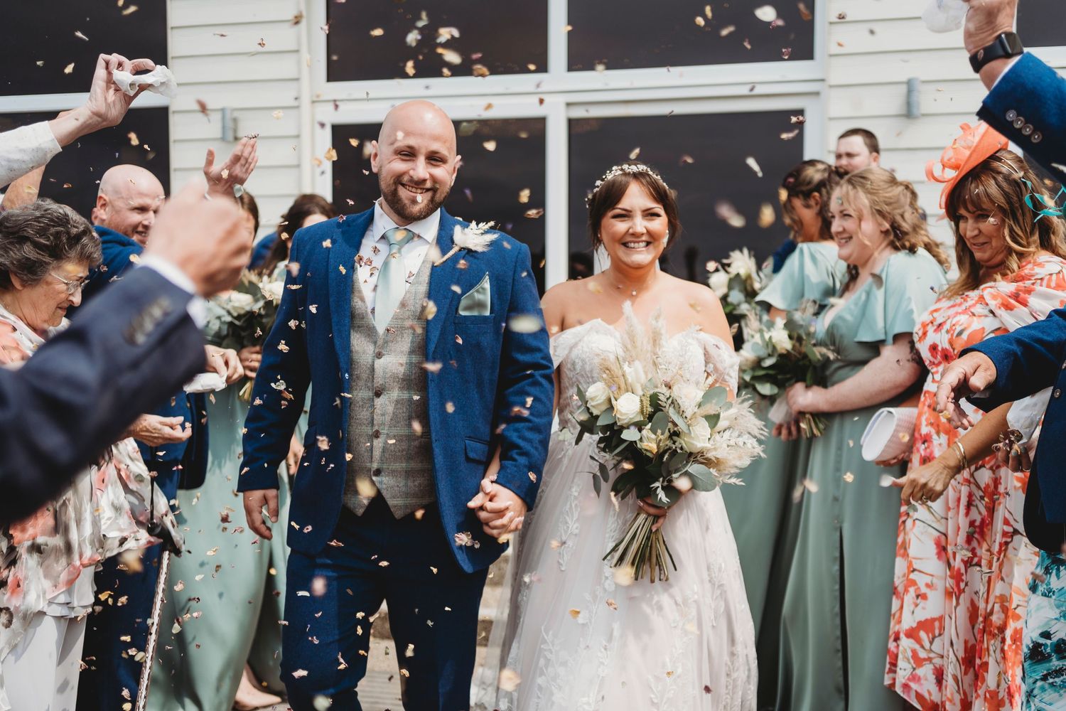 Bride and groom walking through confetti at West Wales wedding in Ceredigion coast