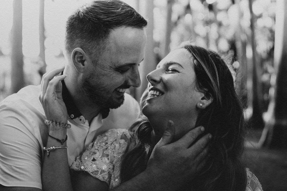 A series of black and white romantic photos showing intimate moments between a couple in an outdoor setting.