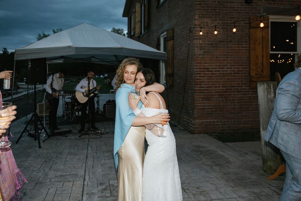 Evening wedding celebration with string lights illuminating an outdoor brick venue space.