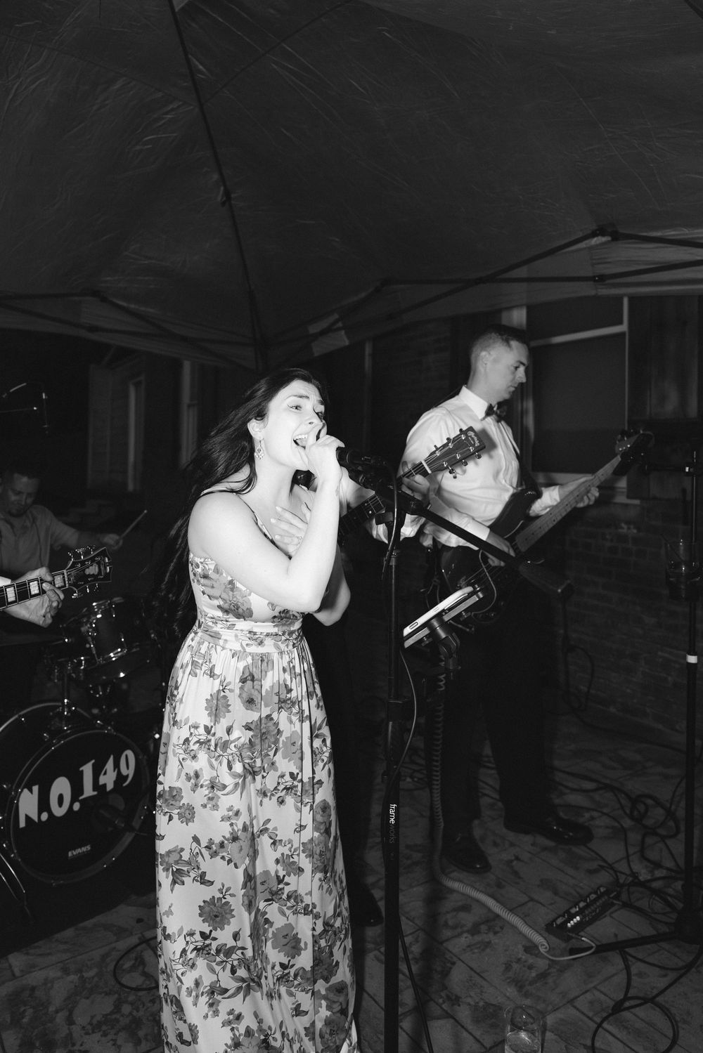 Black and white photo of performers singing on stage at a wedding reception.