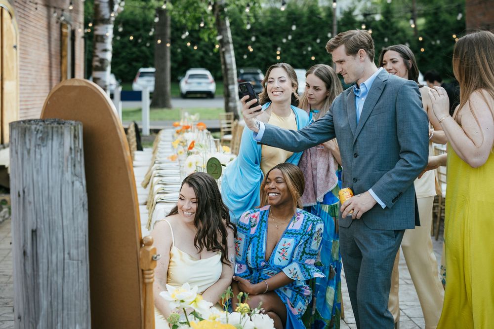 Wedding guests mingle and celebrate at an outdoor reception with drinks and casual conversation.