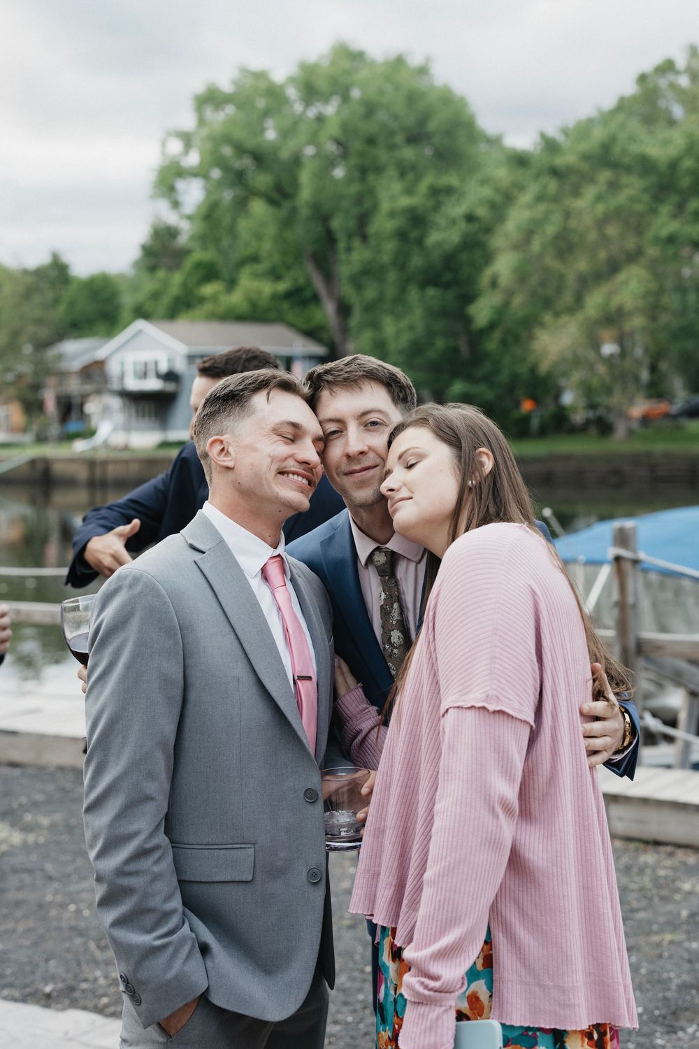 Wedding party sharing candid laughing moments together by the waterfront.