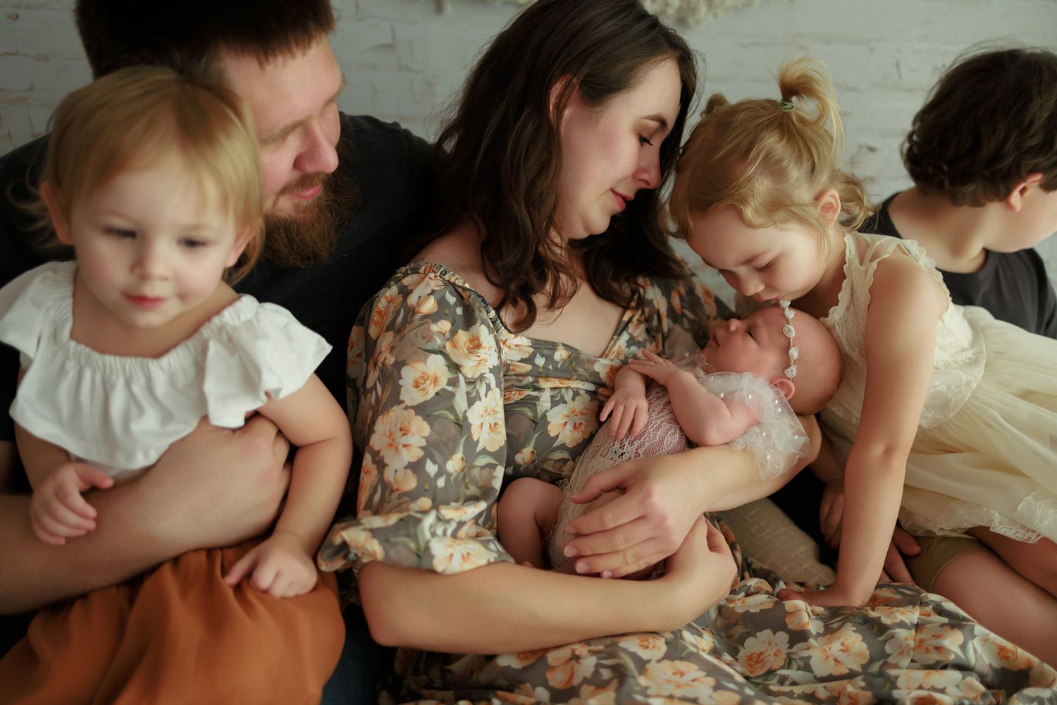 A series of vintage-style photographs showing tender family moments with a baby in cream-colored clothing.