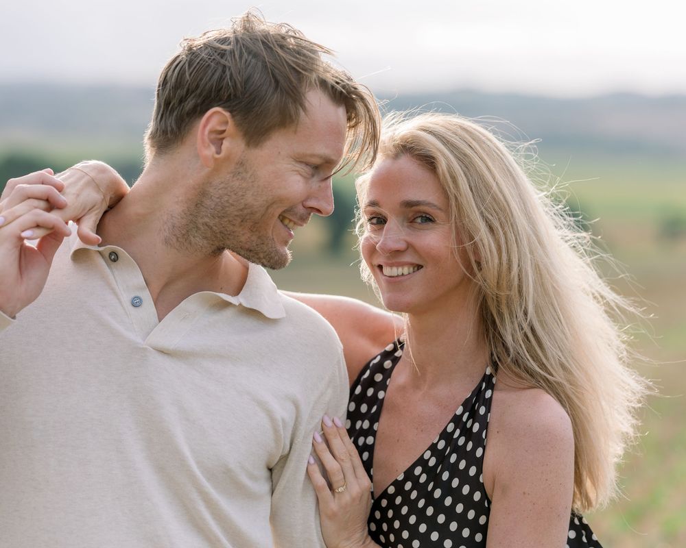 Couple shares an intimate moment together in an outdoor setting at sunset.