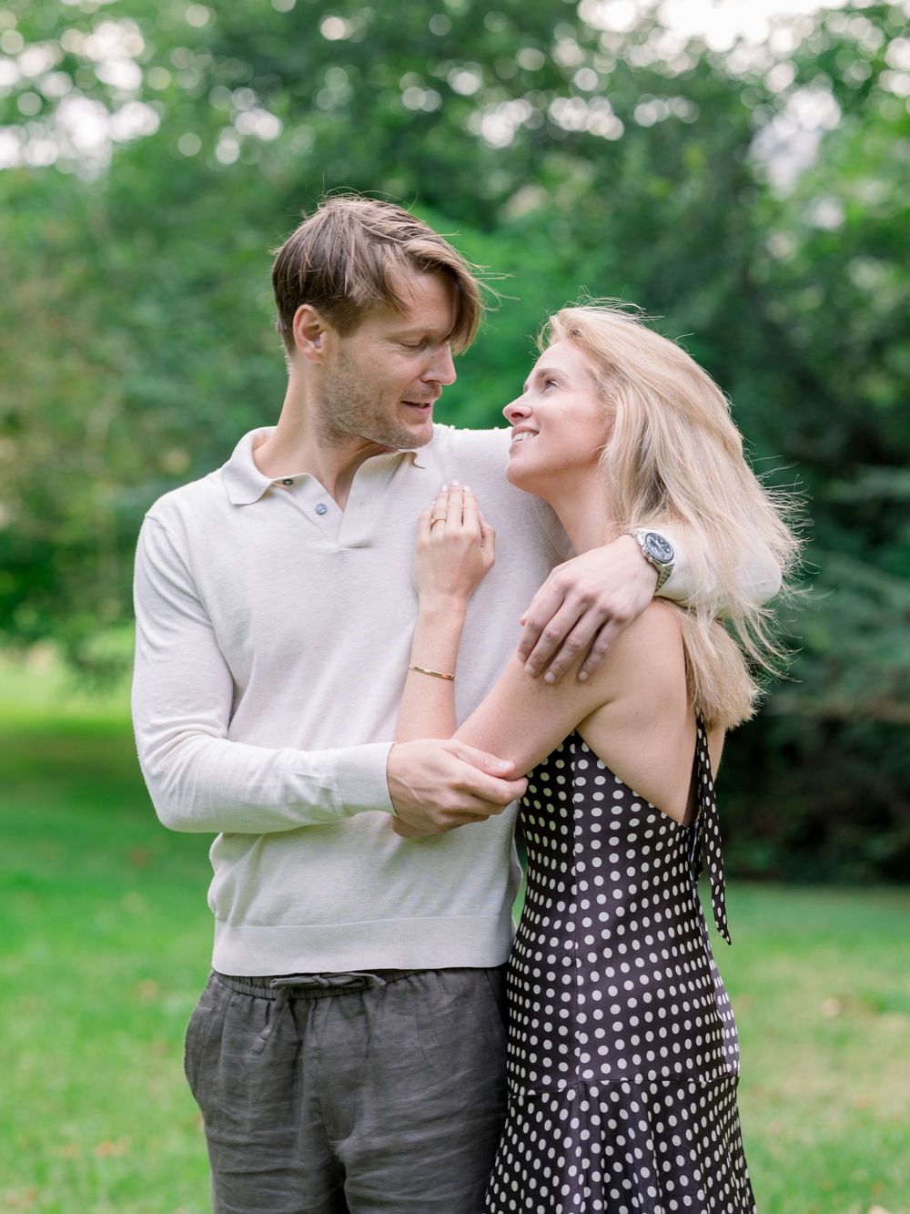 Playful couple embracing in casual attire during outdoor photo session.