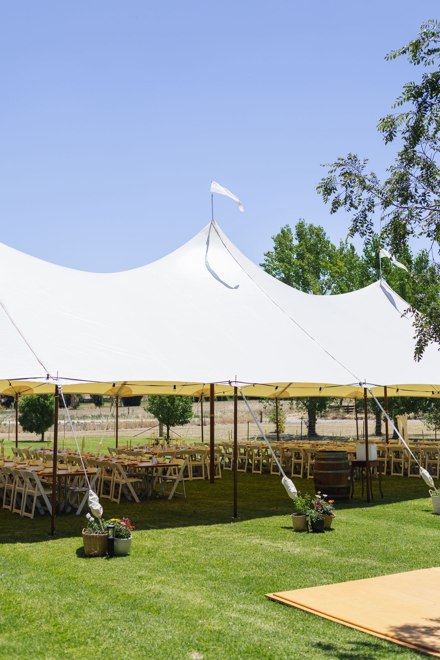 marquee on the lawn with tables and chairs underneath at country wedding