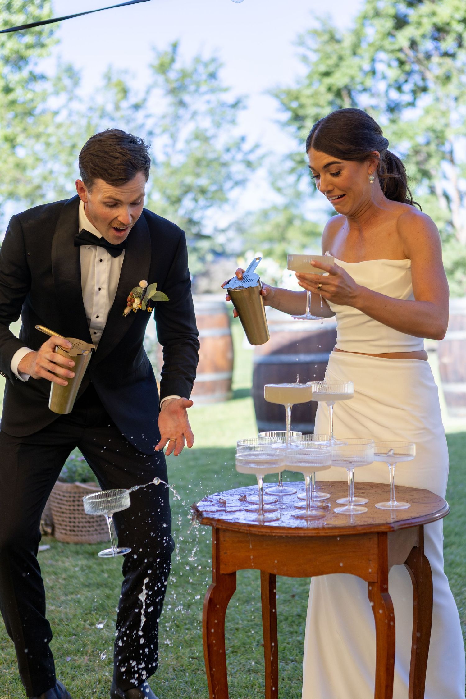 Bride groom spilling margarita tower during reception of country wedding