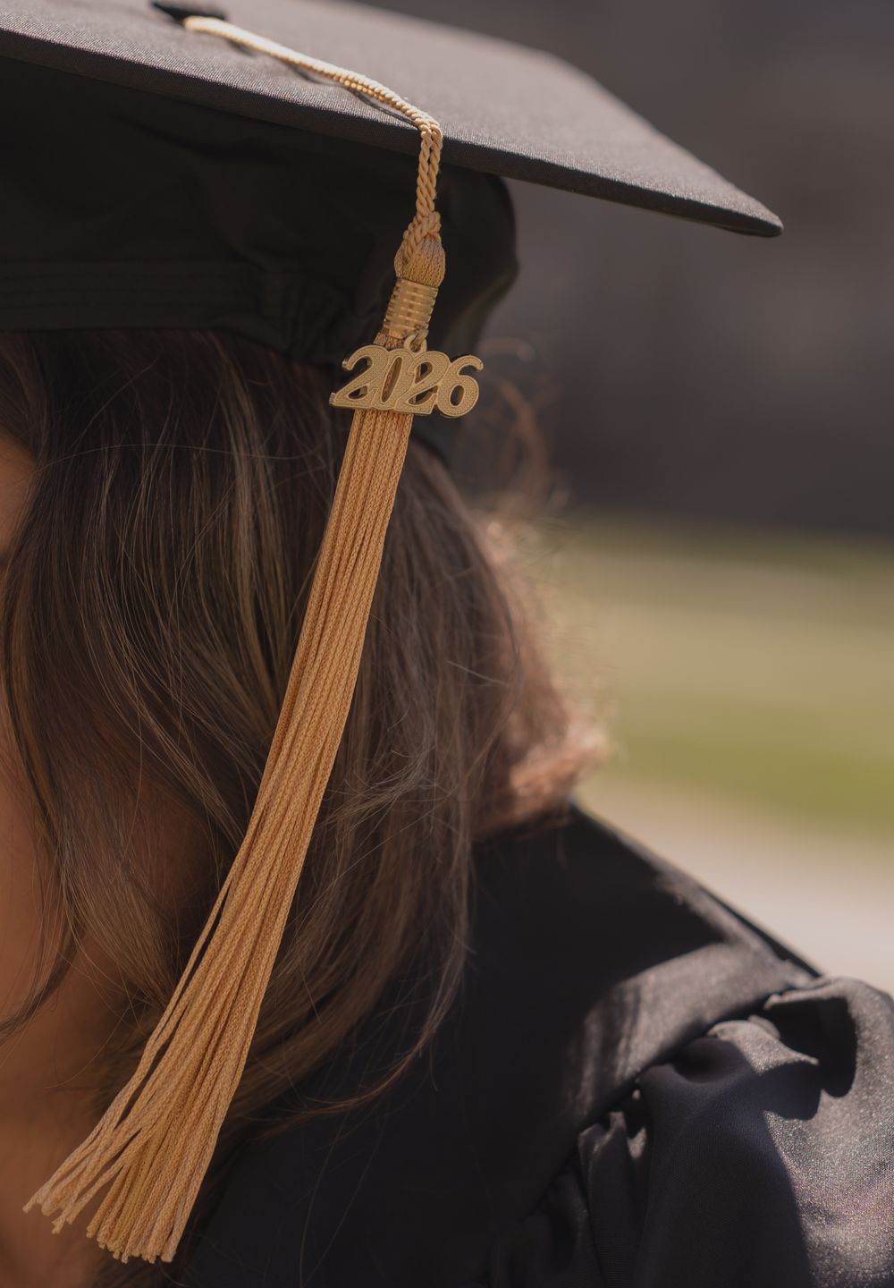 Close-up of a 2026 graduation cap tassel on a student wearing a black mortarboard and gown.