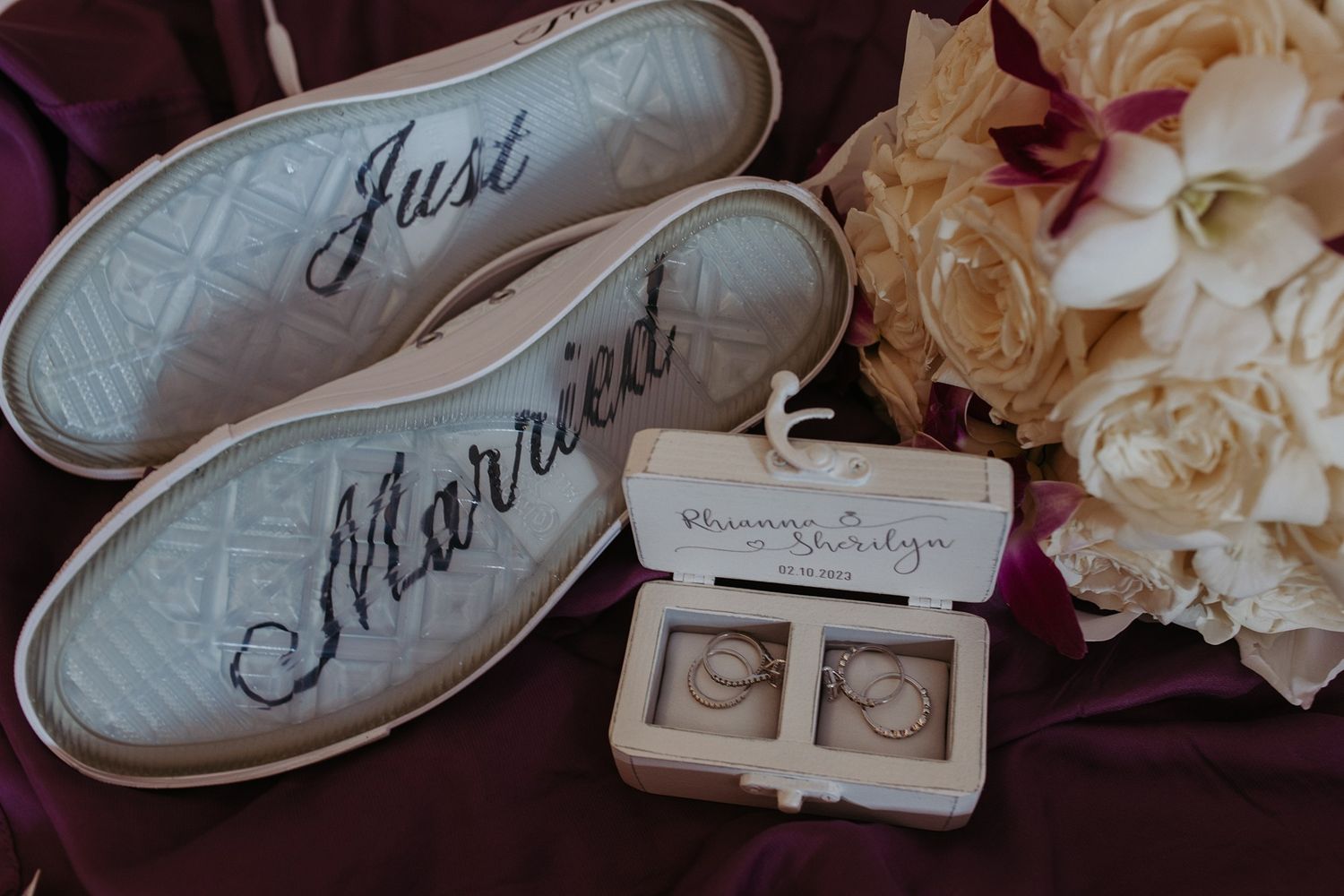 Vintage wedding details including rings and delicate ivory roses arranged on a soft surface.