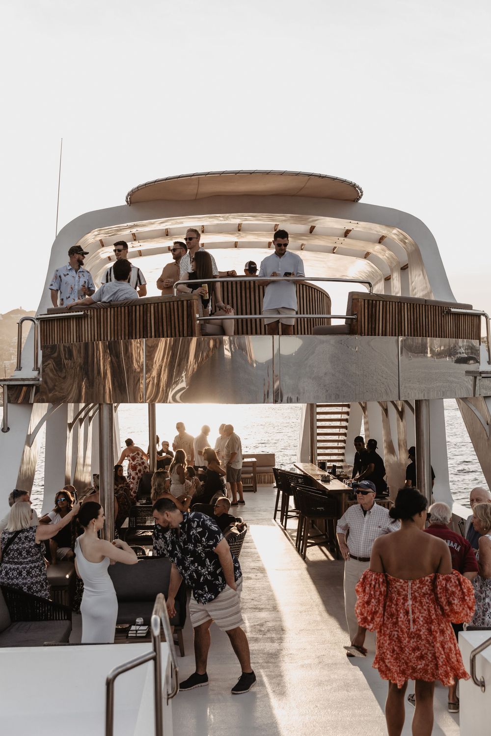 People gather on a luxury boat deck at sunset for a social event with multiple views of the same scene.