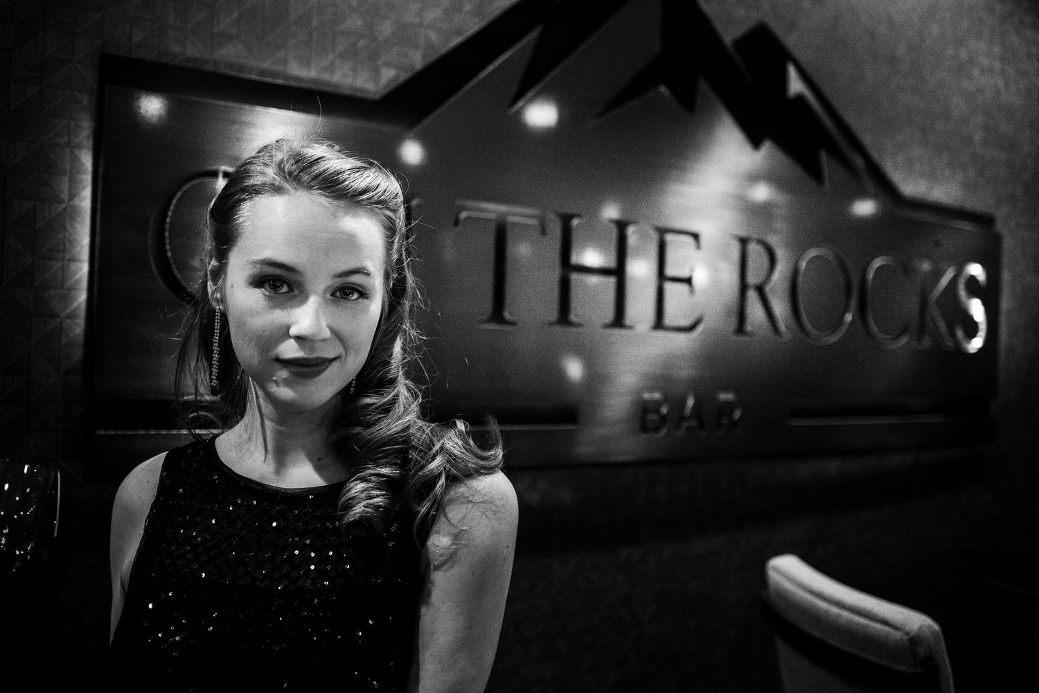 Dramatic black and white photo of nightclub setting with The Rocks signage.