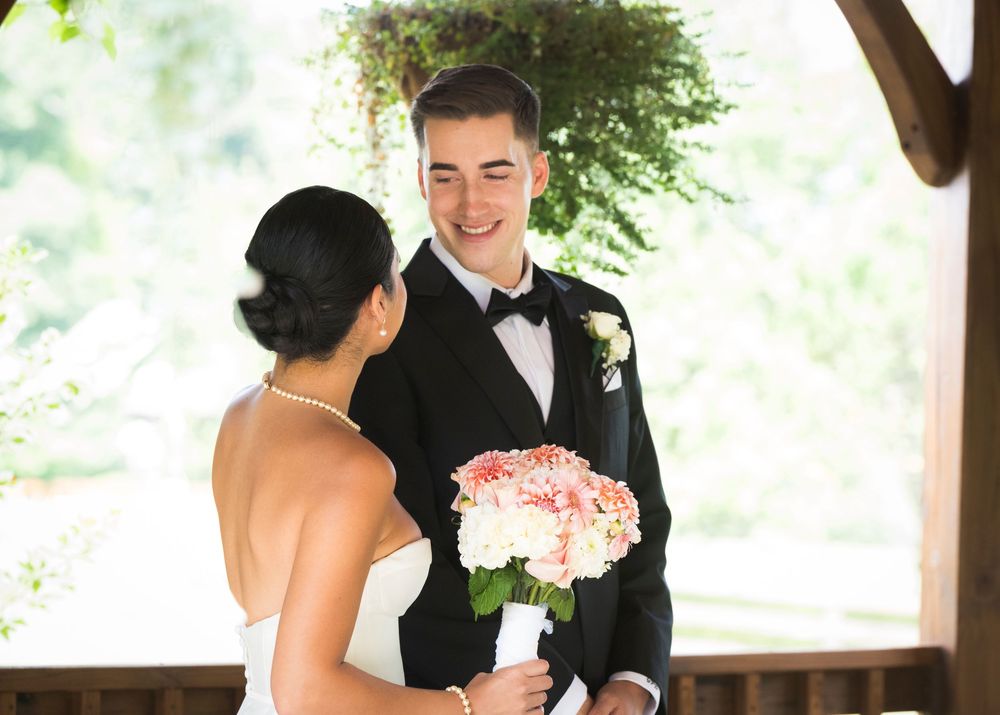 Covered outdoor pavilion with rustic wooden beams decorated for an elegant wedding ceremony.