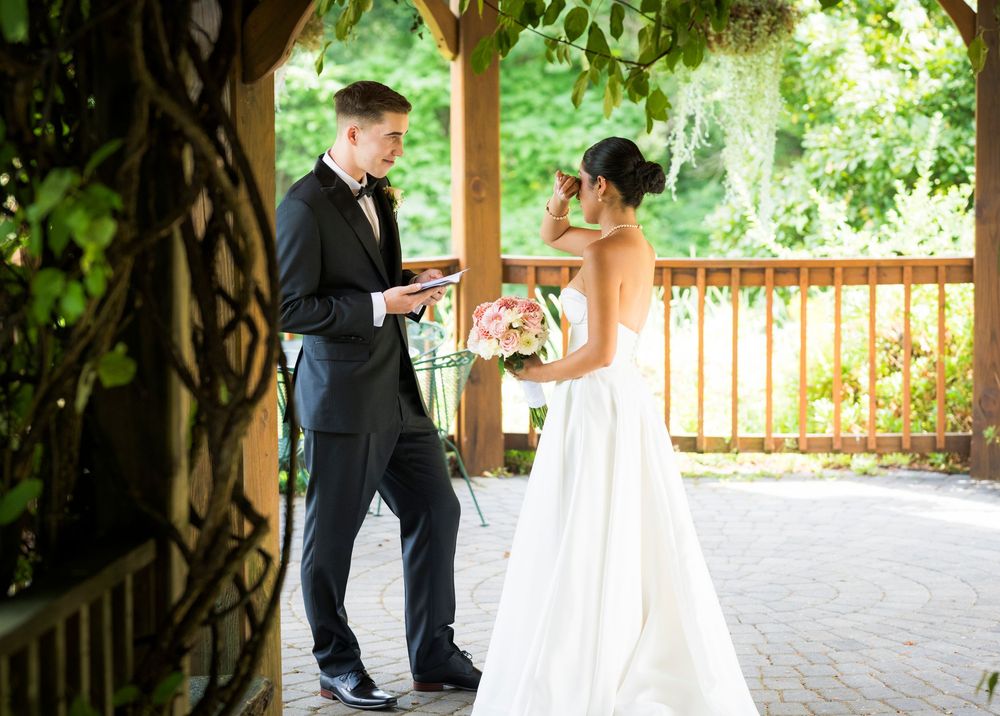 Garden wedding ceremony venue with lush greenery and wooden architecture.